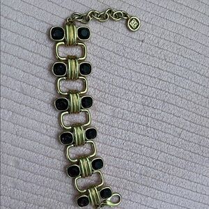 Givenchy …a gold toned metal link design set with dark purple  stones